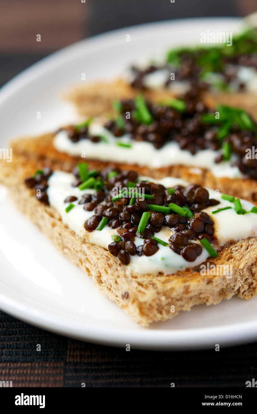 Un délicieux déjeuner avec les lentilles beluga sur l'ail Yaourt de soja. Elle permettrait aussi de belles apéritifs ou le doigt de la nourriture à un parti. Banque D'Images