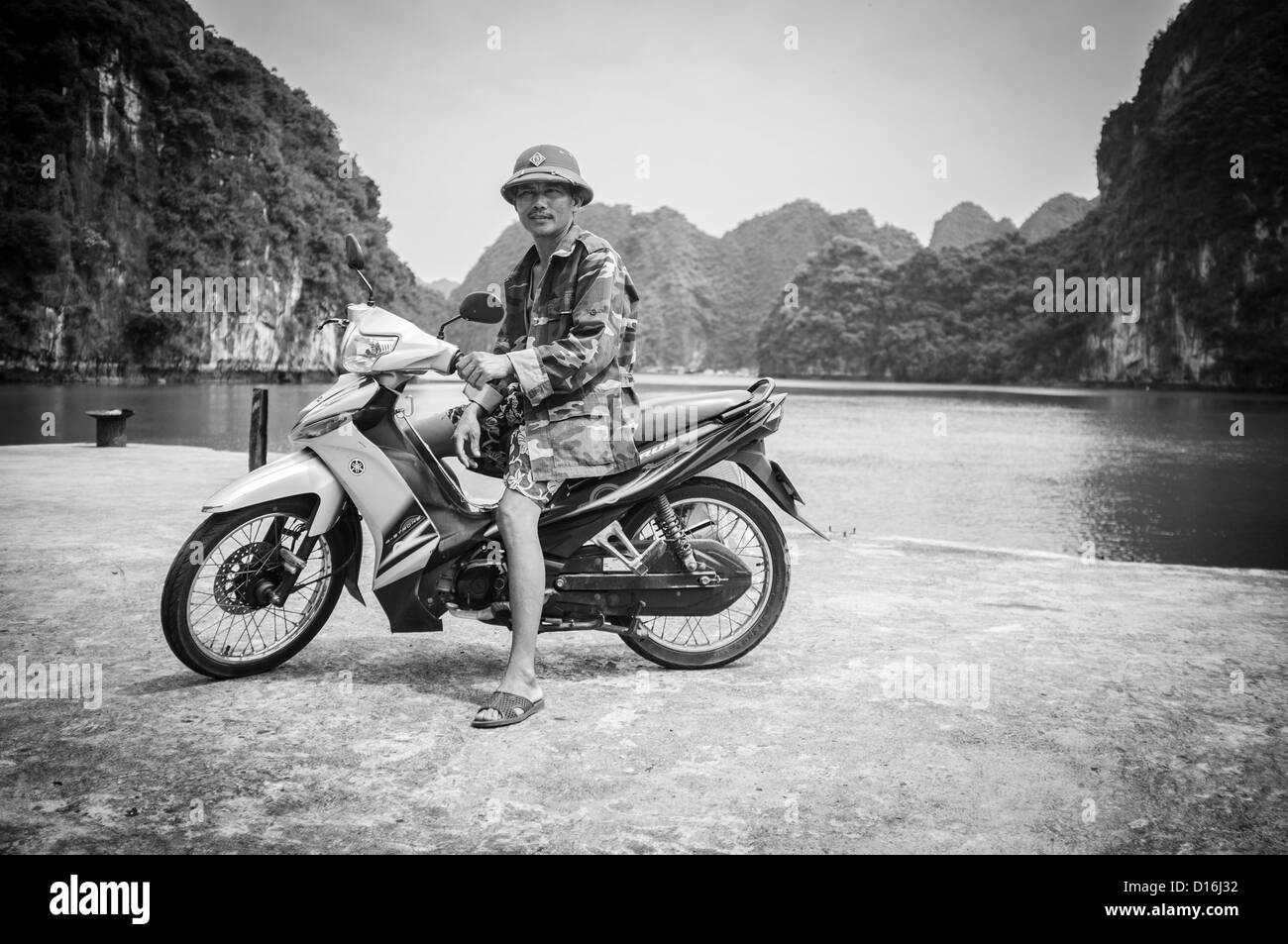 Image noir et blanc d'une femme vietnamienne sur moto. Pris sur l'île de Cat Ba au Vietnam Banque D'Images