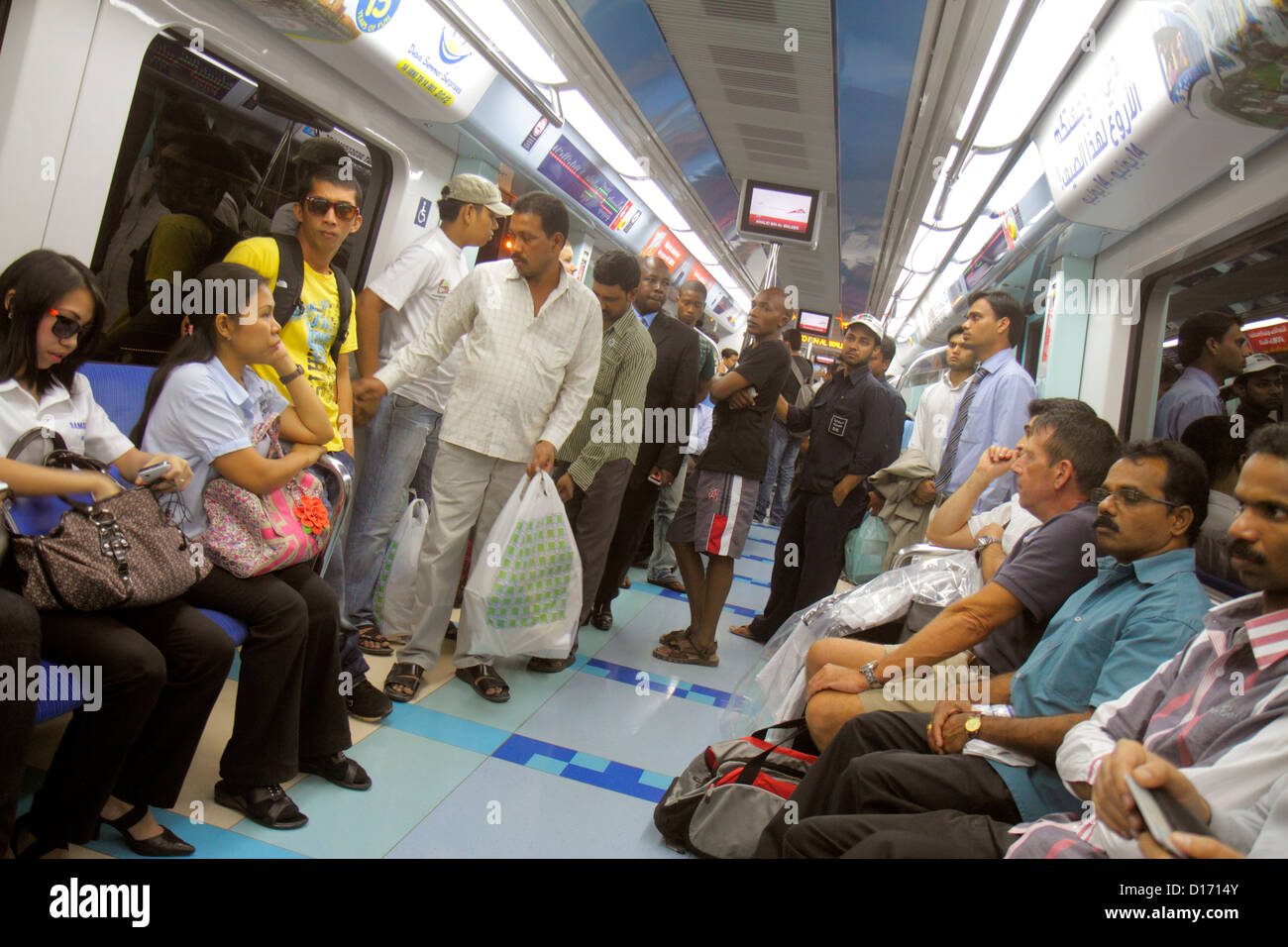 Dubai eau,Emirats Arabes Unis,Deira,Dubai Metro,métro,train,train,Al Rigga Station,Red Line,Anglais,arabe,langue,bilingue,travailleur migrant,travailleurs Banque D'Images