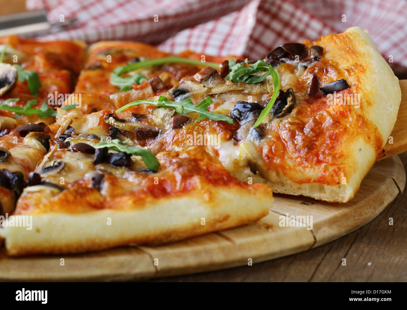 Pizza italienne avec des champignons et des olives sur une planche en bois Banque D'Images