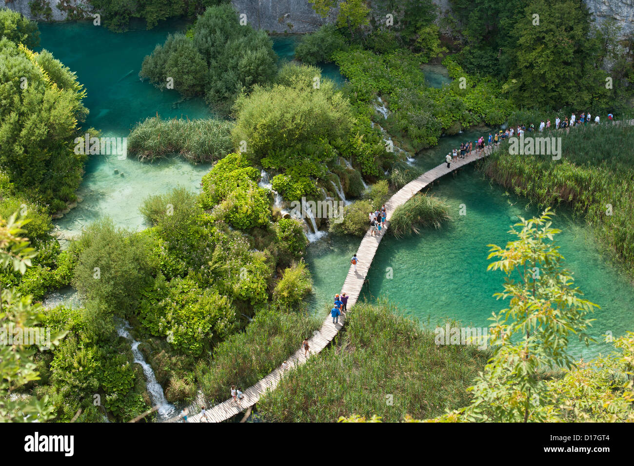 Les touristes à marcher le long des allées en bois dans le parc national des Lacs de Plitvice en Croatie. Banque D'Images