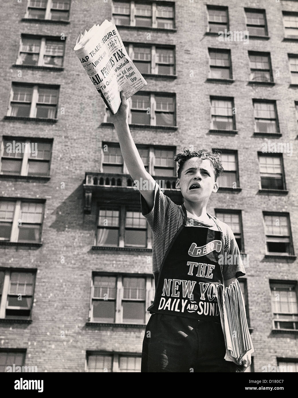 Garçon à vendre des journaux dans la rue, New York City Banque D'Images