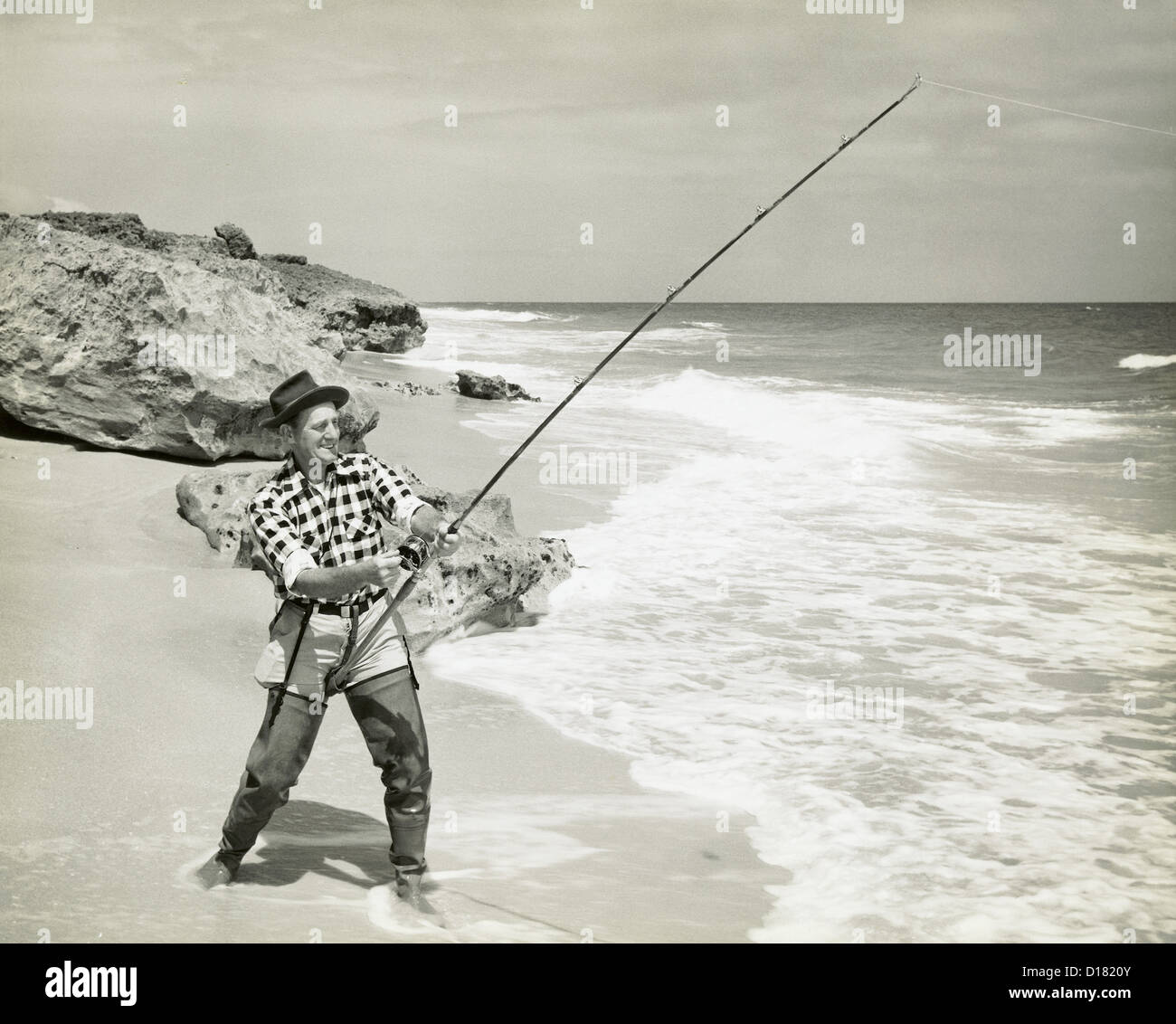 La pêche dans l'homme à partir de la plage de l'océan Banque D'Images