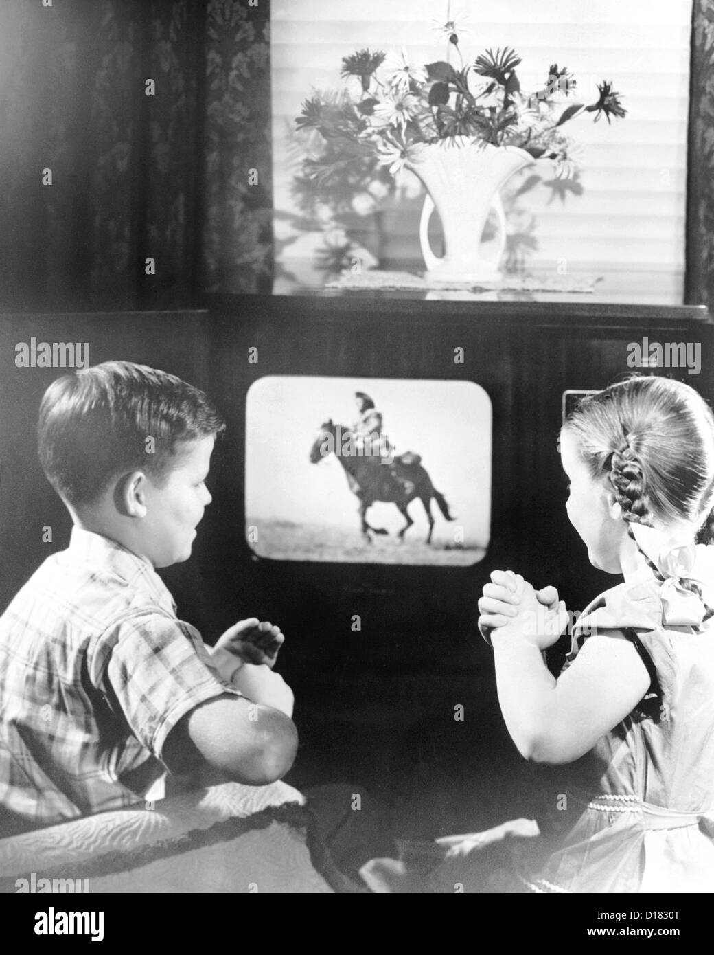 Garçon et fille regardant la télévision sur cowboy Banque D'Images