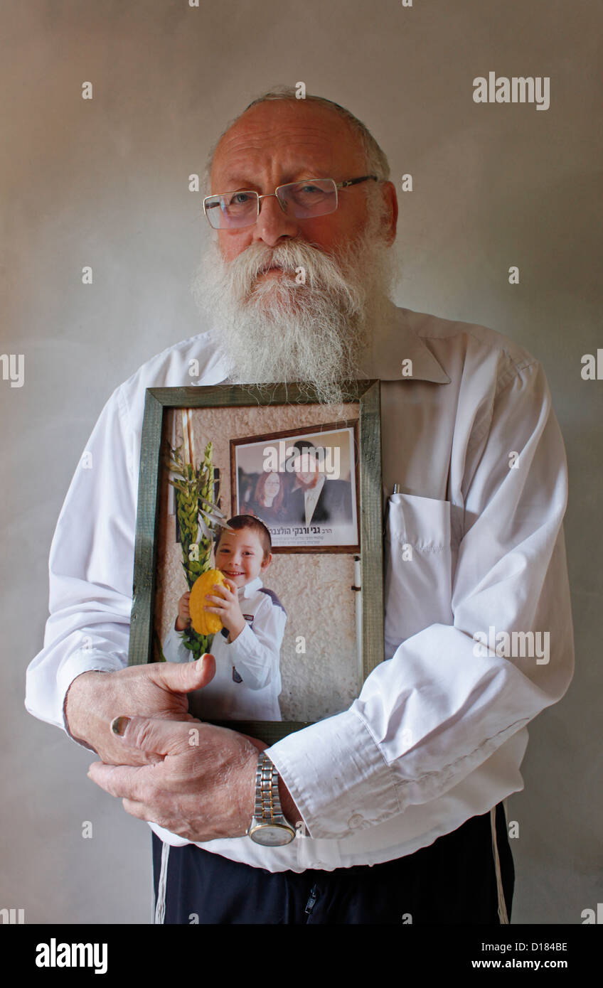Un juif religieux de Chabad-Lubavitch un mouvement chasidique dans le judaïsme orthodoxe tenant leur petit-fils photo en Israël Banque D'Images