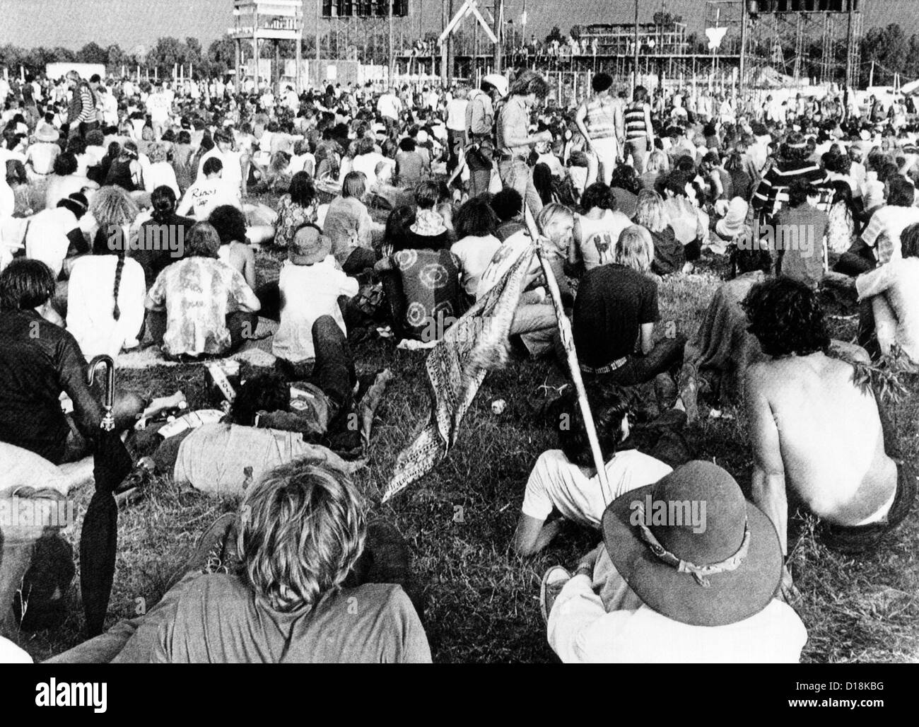 Les jeunes à l'Hippie "Célébration de la vie' rock festival. Les travailleurs de la construction de mettre la touche finale sur la scène géante pour Banque D'Images