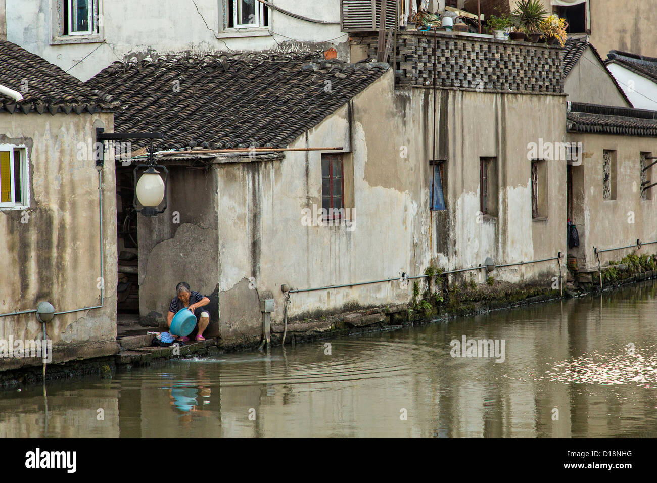 Vêtements femme âgée se lave le long du canal Shantang à Suzhou, Chine. Banque D'Images