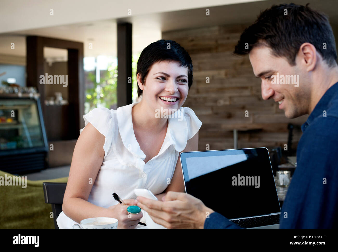 L'homme et la femme à café avec ordinateur portable et téléphone portable Banque D'Images