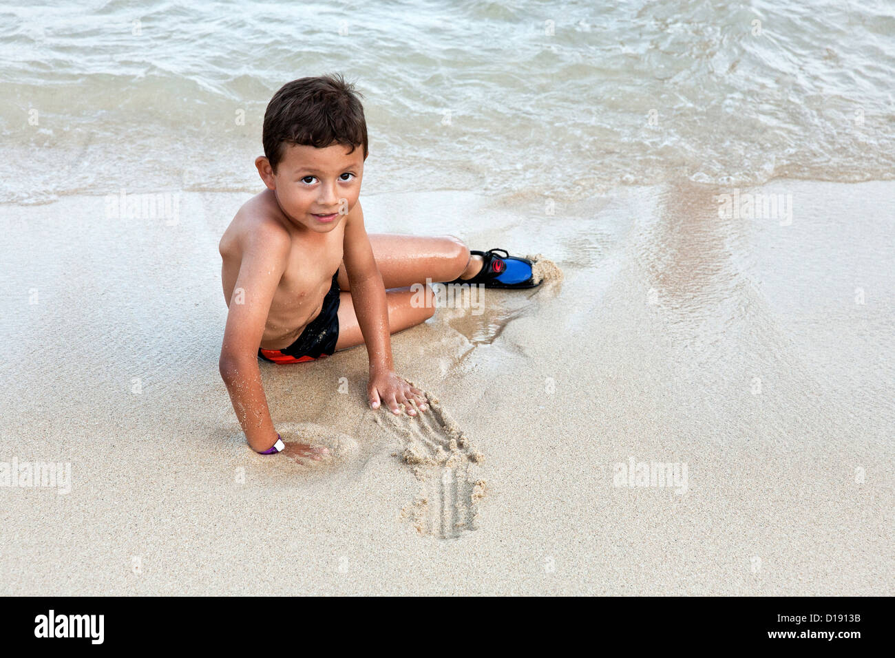 Petits yeux lumineux garçon mexicain faisant sa marque jouer dans le sable  au bord de l'eau Playa plage de Santa Cruz Huatulco Mexique Photo Stock -  Alamy