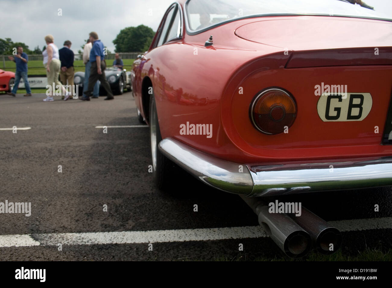 L'arrière d'un classic Ferrari supercar garée à une exposition de voiture avec des gens marcher par elle. Banque D'Images