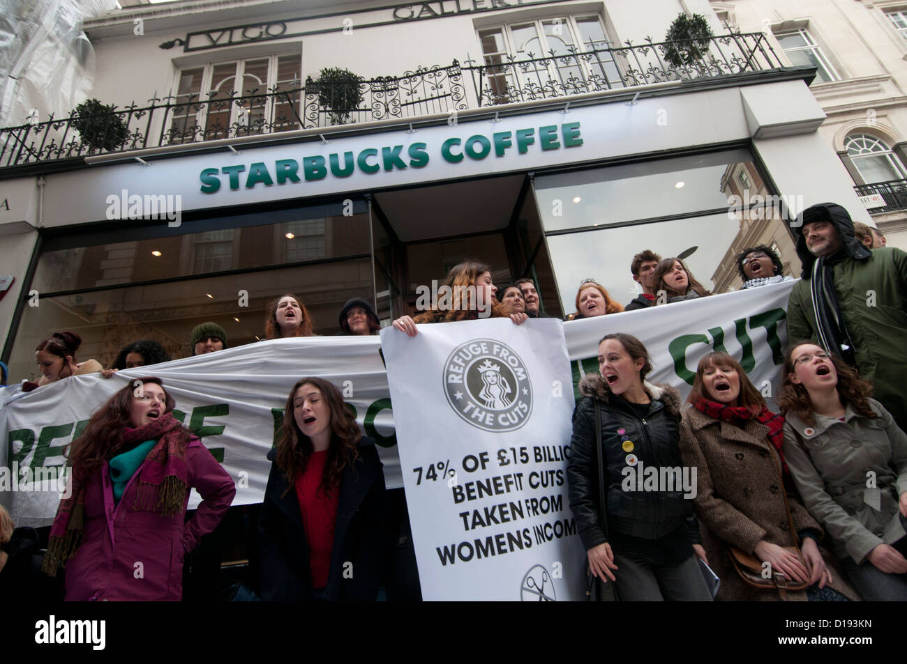 UK Uncut flashmob manifester devant Starbucks . Les manifestants tenir un panneau disant 74 % des réductions des prestations de revenus des femmes. Banque D'Images