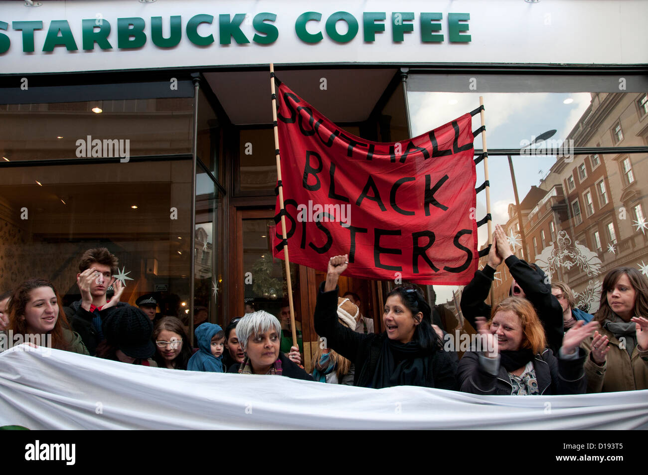 UK Uncut flashmob manifester devant Starbucks .Southall Black Sisters souligner le coût des réductions imposées à l'égard des femmes. Banque D'Images