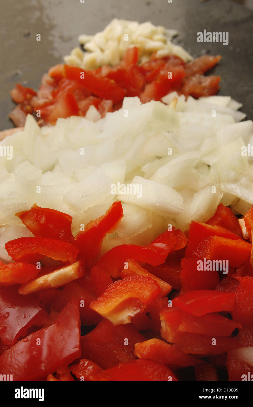 Pyramide alimentaire de poivrons, oignons, tomates et ail sur en planche à découper Banque D'Images