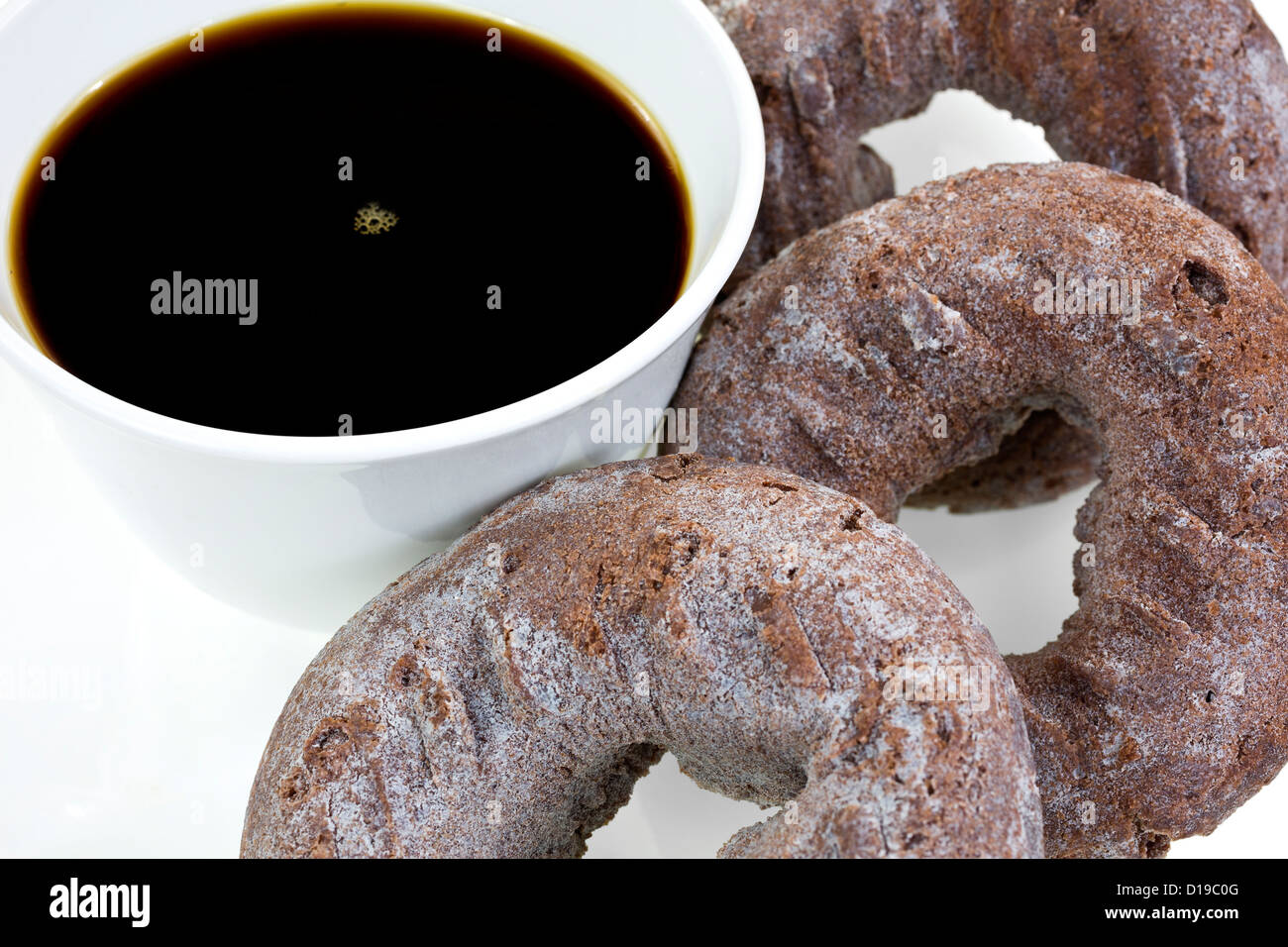 Une vue étroite d'une tasse de café noir avec des beignets chocolat plusieurs. Banque D'Images