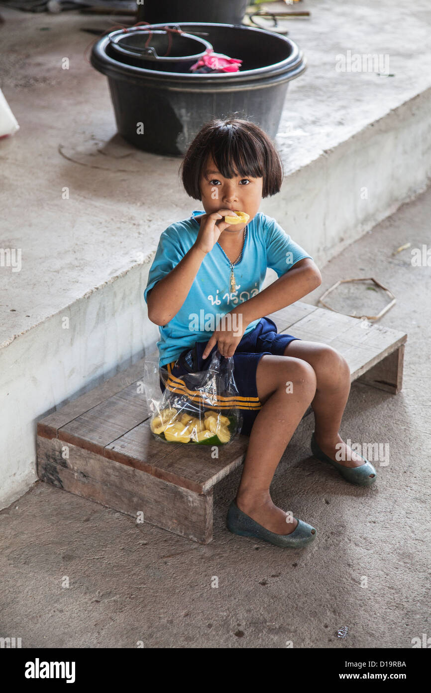 Thai girl eating at Tha Kha marché flottant, près de Bangkok, Thaïlande Banque D'Images