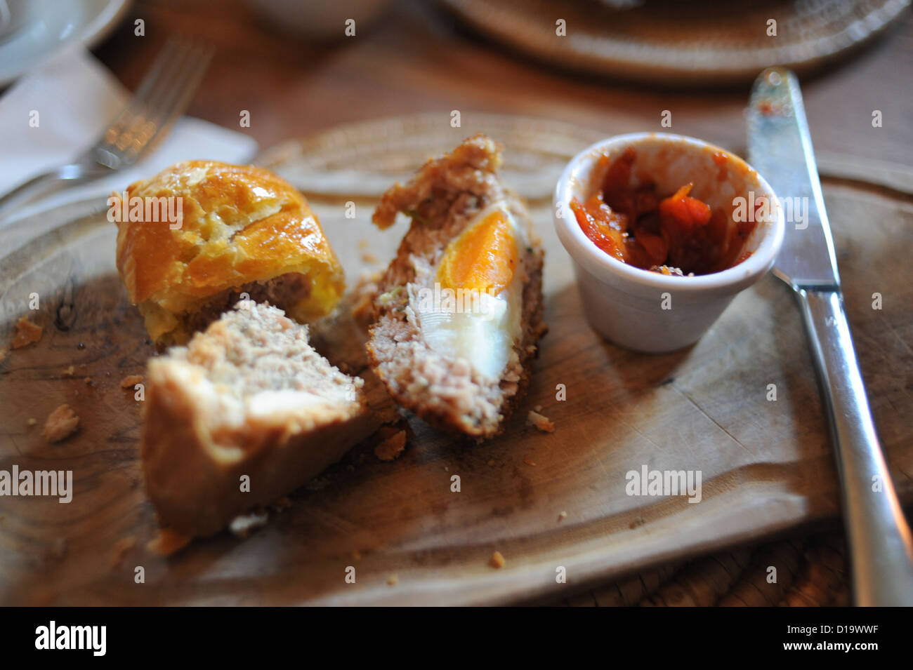 Assiette de petits pains de saucisse faits maison, tarte au porc et un scotch egg servi dans un café pour le déjeuner planche en bois Banque D'Images