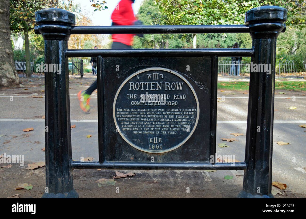 Jogger passant une plaque commémorative célébrant 'Rotten Row' près de Hyde Park, Londres, UK. Banque D'Images