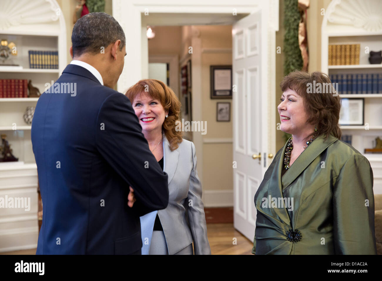 Le président américain Barack Obama parle avec Natoma Canfield, droite, et sa soeur, Connie Anderson, dans le bureau ovale de la Maison Blanche, 12 décembre 2012 à Washington, DC. Canfield a écrit au président en 2010 sur la façon dont elle a perdu son assurance maladie pendant la lutte contre le cancer. Banque D'Images