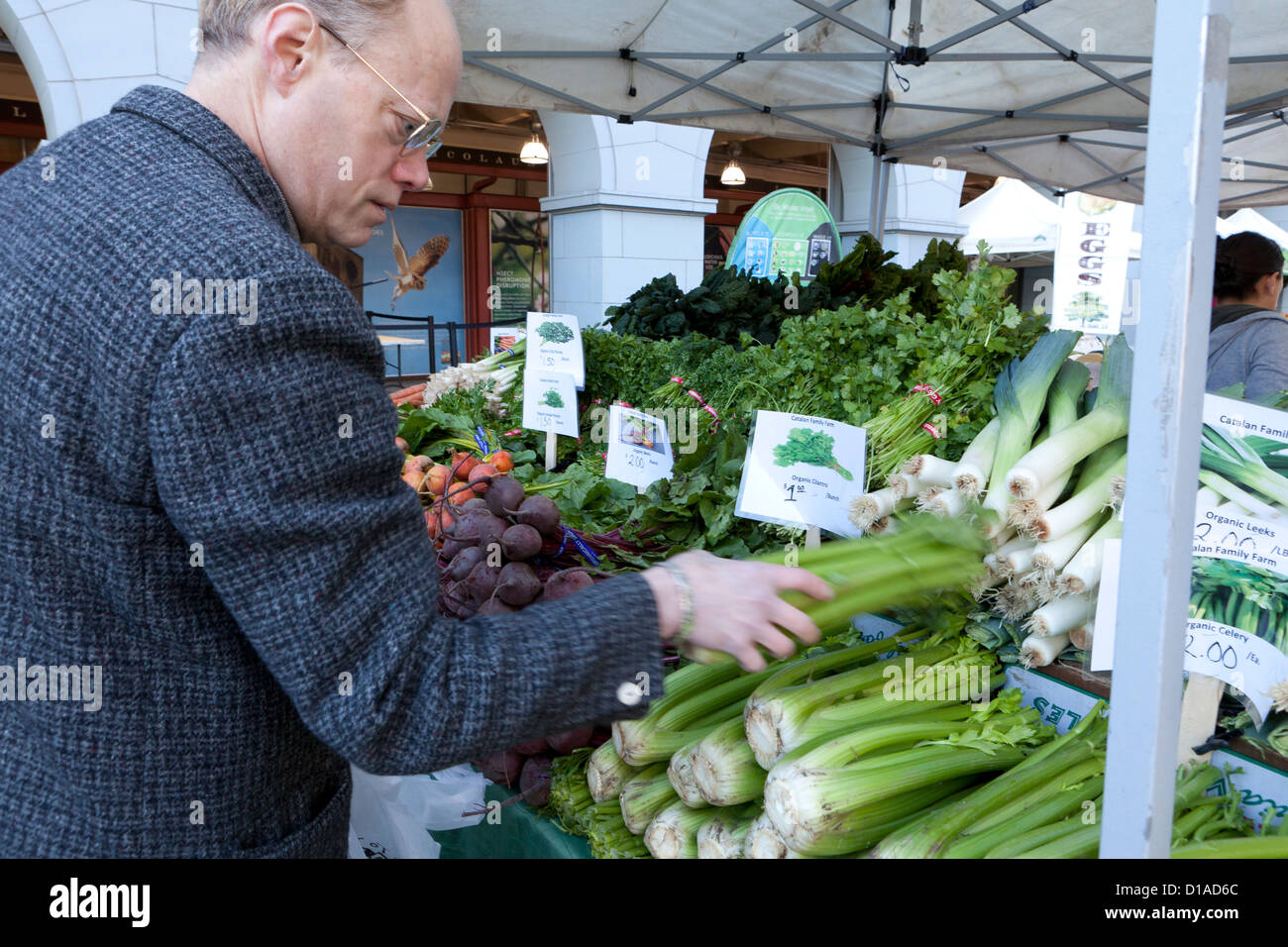 Homme âgé l'achat au marché des agriculteurs biologiques céleri - San Francisco, California USA Banque D'Images