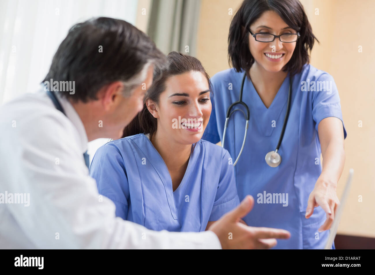 Médecin et infirmières looking at laptop Banque D'Images