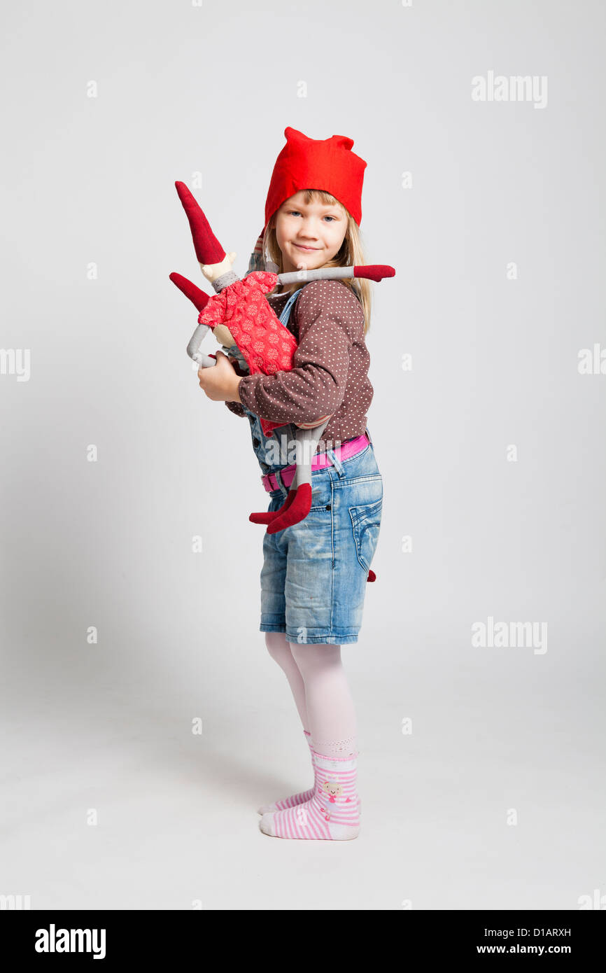 Studio portrait of happy smiling young girl holding Christmas elf poupée dans l'article Banque D'Images