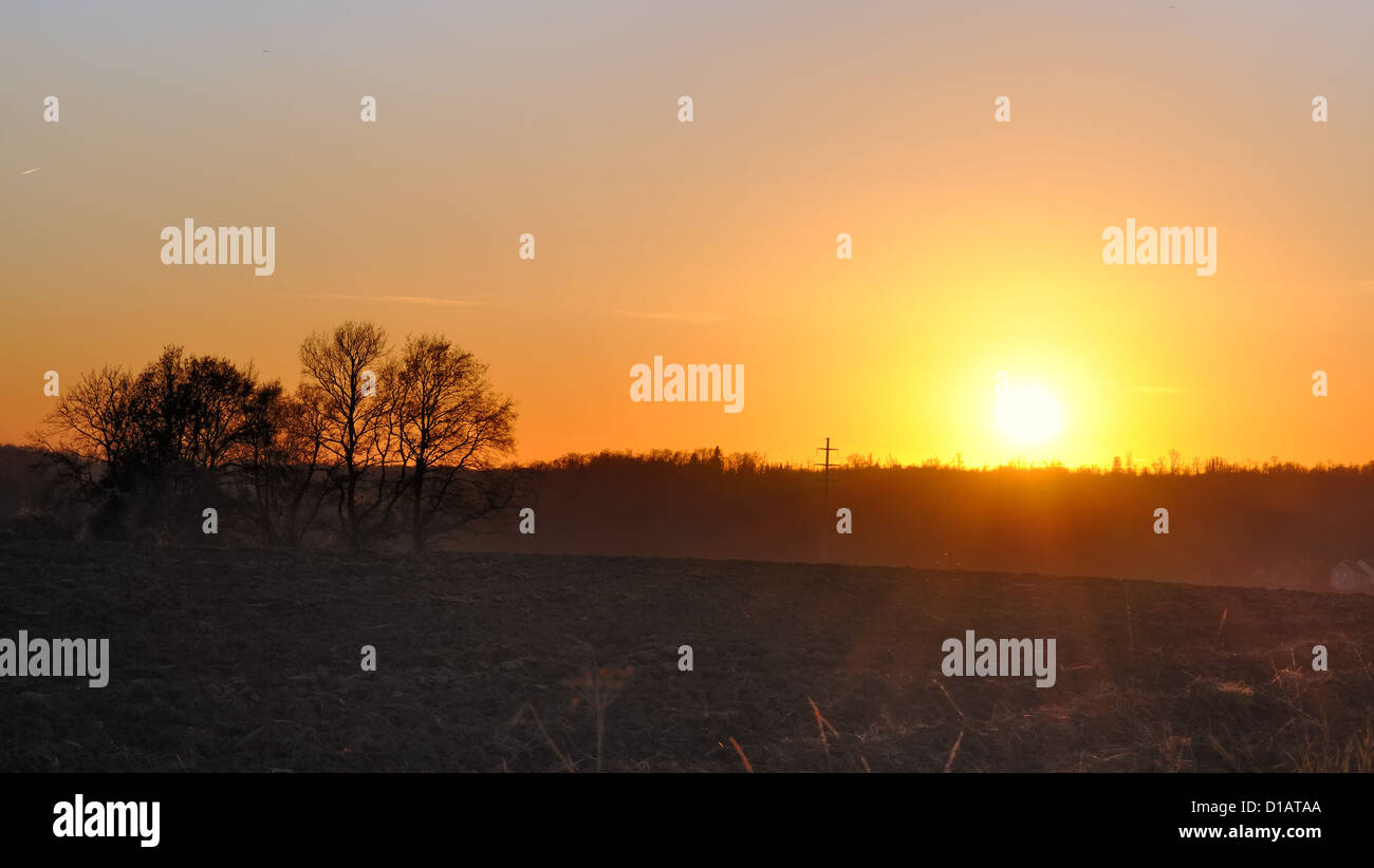 Coucher du soleil sur l'horizon entre ciel et terre ferme Banque D'Images