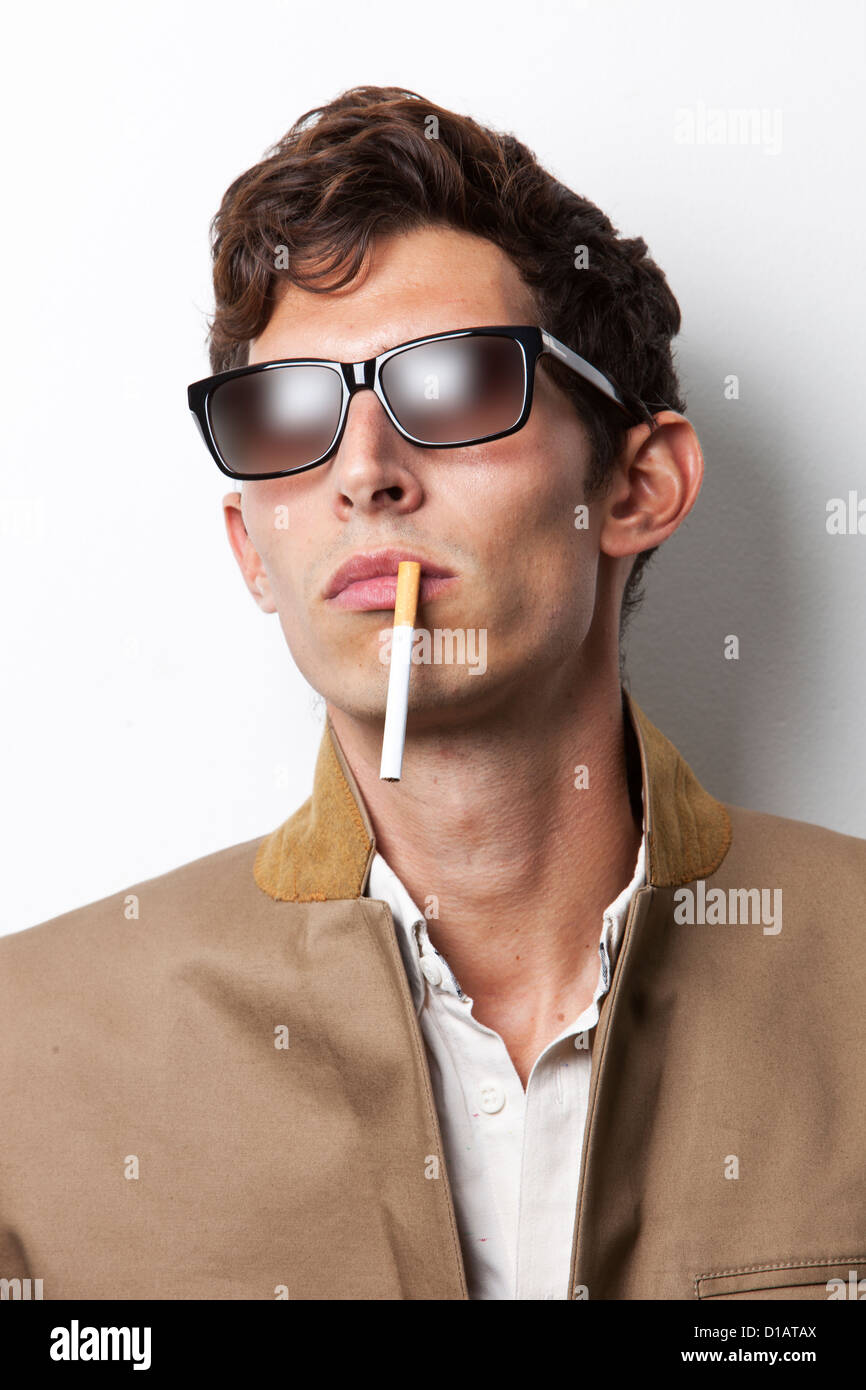 Jeune homme à lunettes de cigarette Banque D'Images