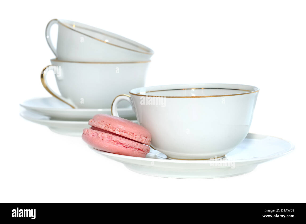 Macaron rose sur la soucoupe en porcelaine d'une tasse de café Banque D'Images