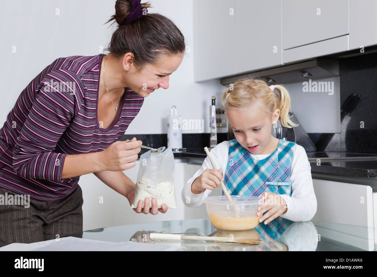 Happy mother daughter baking together in kitchen Banque D'Images