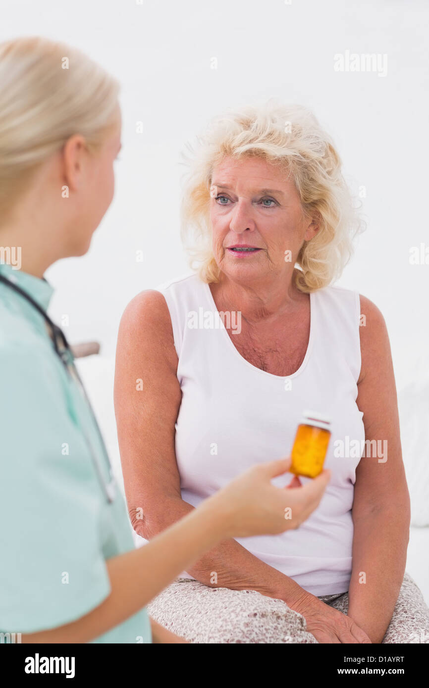 Médecin parle d'une bouteille de pilules à son patient Banque D'Images