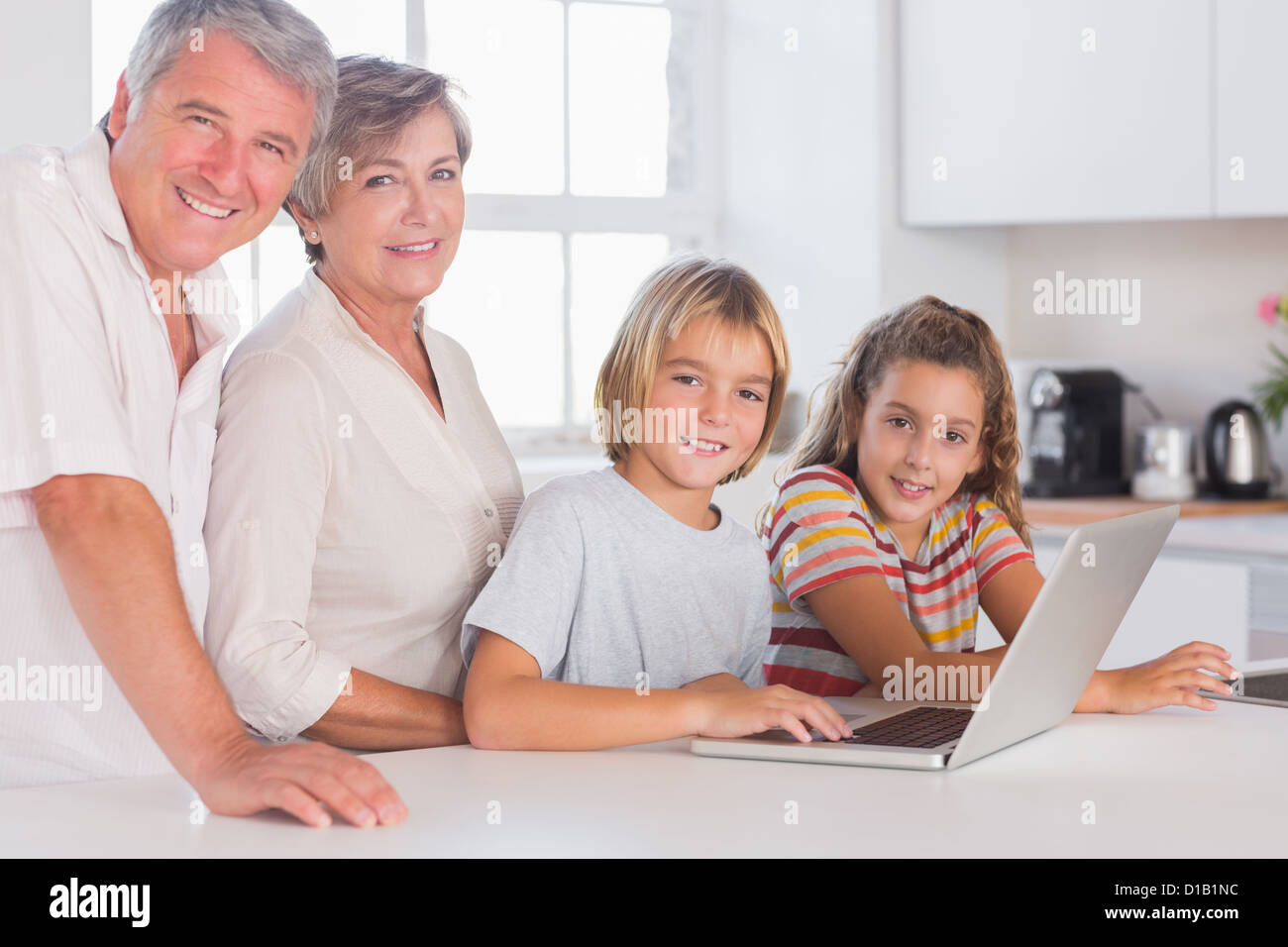 Les grands-parents et enfants regardant la caméra avec coffre à l'avant Banque D'Images