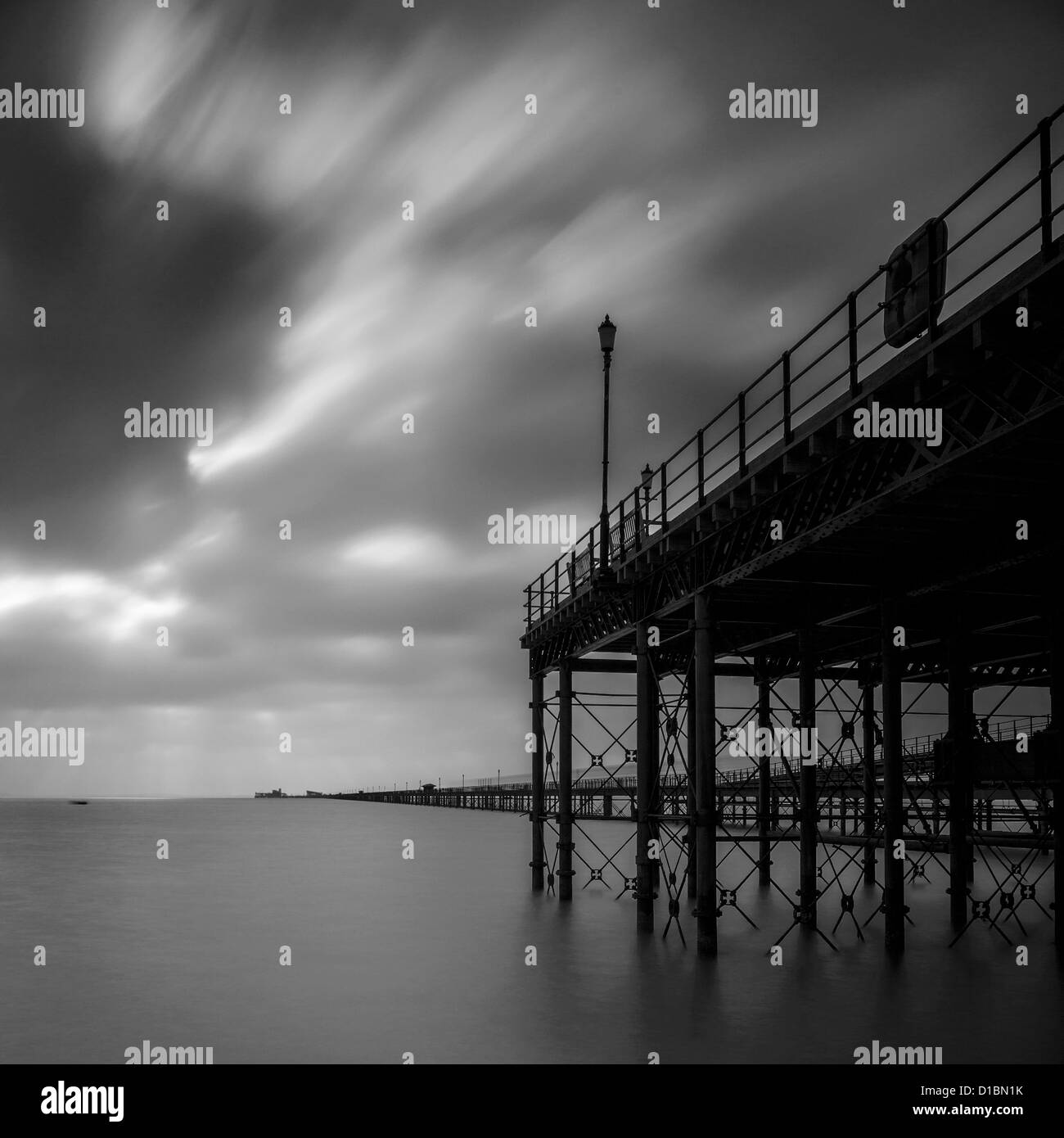 Southend, UK. 13 décembre 2012. Un faible soleil tente de briser une couverture de nuage sur une journée froide et sombre à Southend-on-Sea. Une longue exposition a aplani la mer agitée Banque D'Images