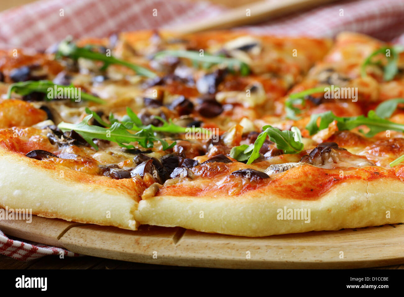 Pizza italienne avec des champignons et des olives sur une planche en bois Banque D'Images