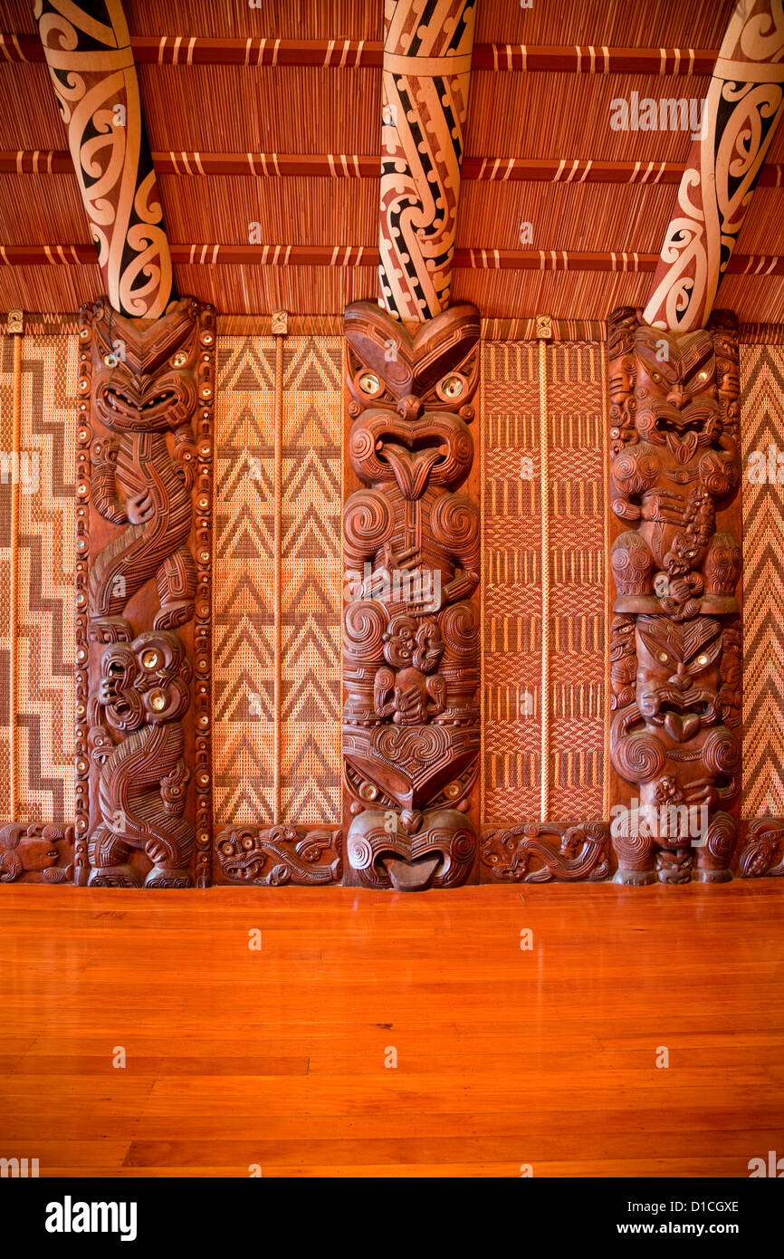 Traditionnel Maori sculpté figure, appelé Poupou, soutenant le toit de chevrons de la meeting house, site du Traité de Waitangi. Banque D'Images