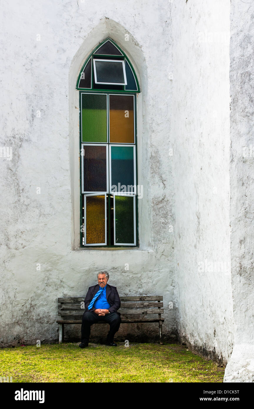Un homme est assis à l'extérieur de l'Église Chrétienne des Îles Cook d'Avarua. Banque D'Images