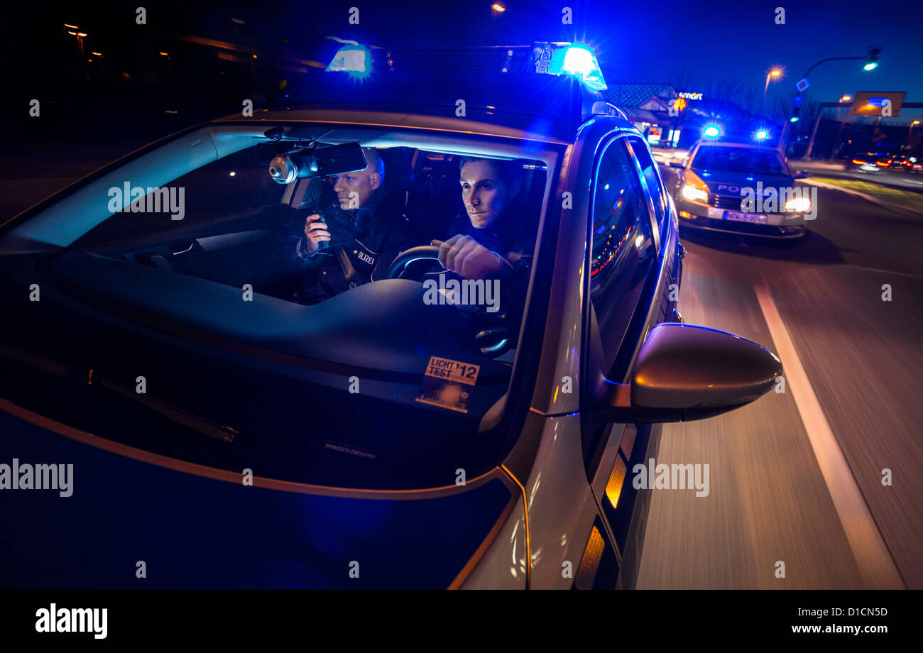 Voiture de police avec feux bleus clignotants, avertisseur sonore, conduite  rapide au cours d'une mission d'urgence Photo Stock - Alamy