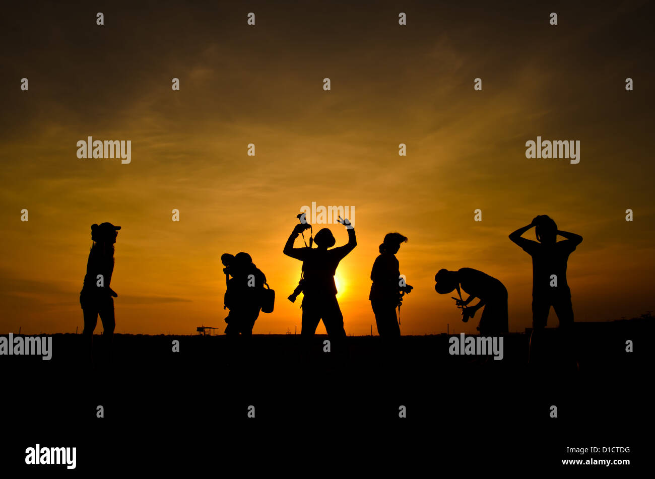 Silhouette d'amis photographe dans le coucher du soleil. Banque D'Images