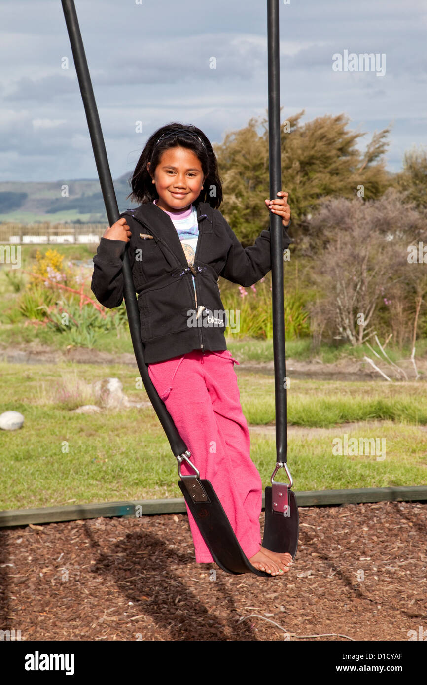 7-year-old fille Maori sur Swing, village Maori Ohinemutu, Rotorua, île du nord, en Nouvelle-Zélande. Banque D'Images