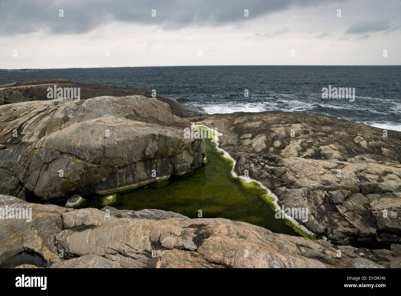 Piscine d'eau salée avec des gisements de sel sur une petite île, avec la mer au-delà, de la côte ouest de la Suède Banque D'Images