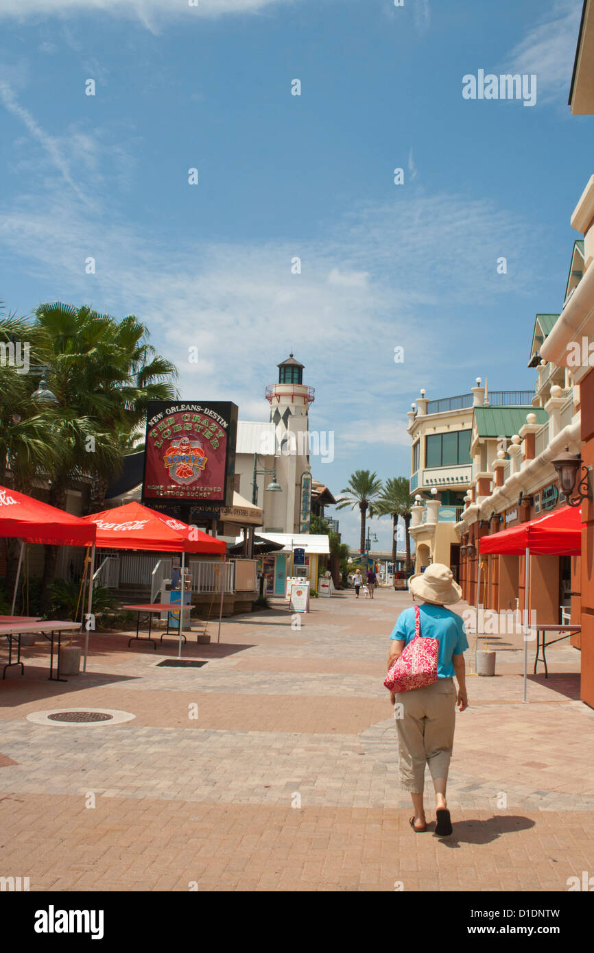 Femme plus âgée, promenades le long de la rue Harbour Village en face de l'hôtel Grand de Destin Florida USA Banque D'Images