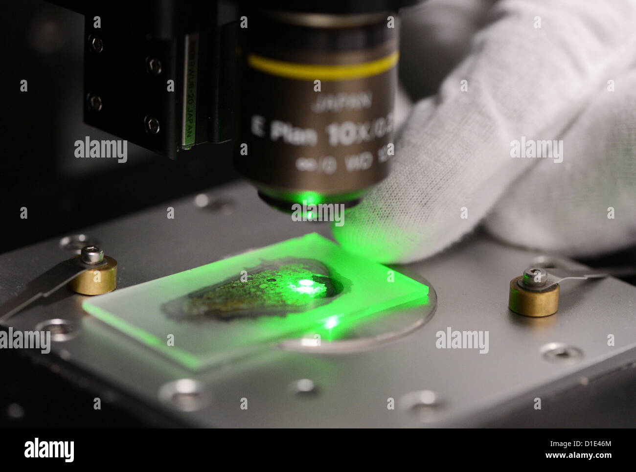 La section fine d'une météorite, qui est descendu à Oslo en mars 2012, est représenté sur un objet bac sous un microscope Raman et est examiné en l'elpf de laser vert à l'Institut de recherche planétaire de l'Agence aérospatiale allemande (DLR) à Berlin, Allemagne, 07 décembre 2012. La composition de la météorite peuvent être analysés par cette méthode. Photo : Jens Kalaene Banque D'Images