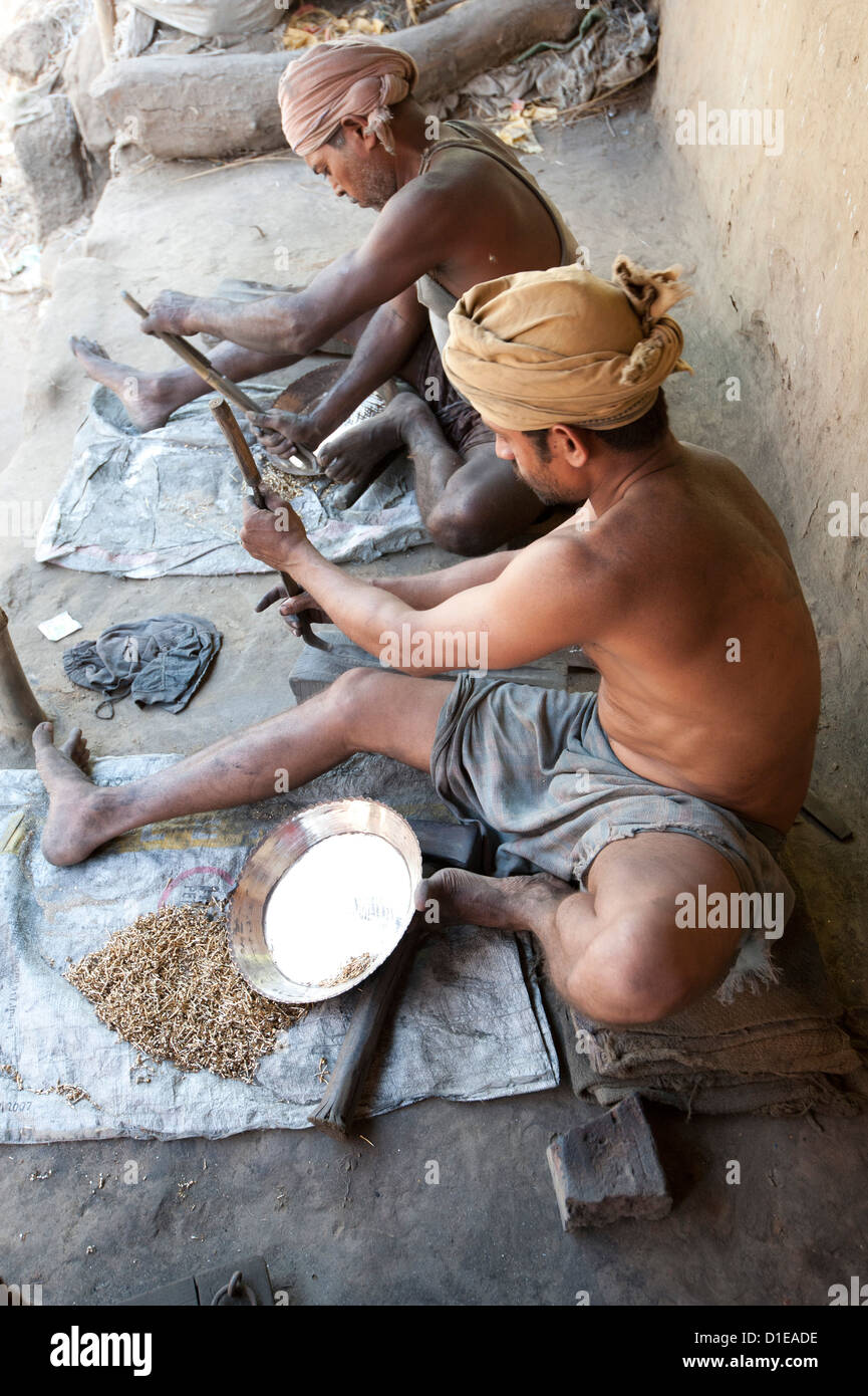 Deux hommes de la surface de lissage des plats en laiton à l'extérieur de la fonderie, Hirapur village, Orissa, Inde, Asie Banque D'Images