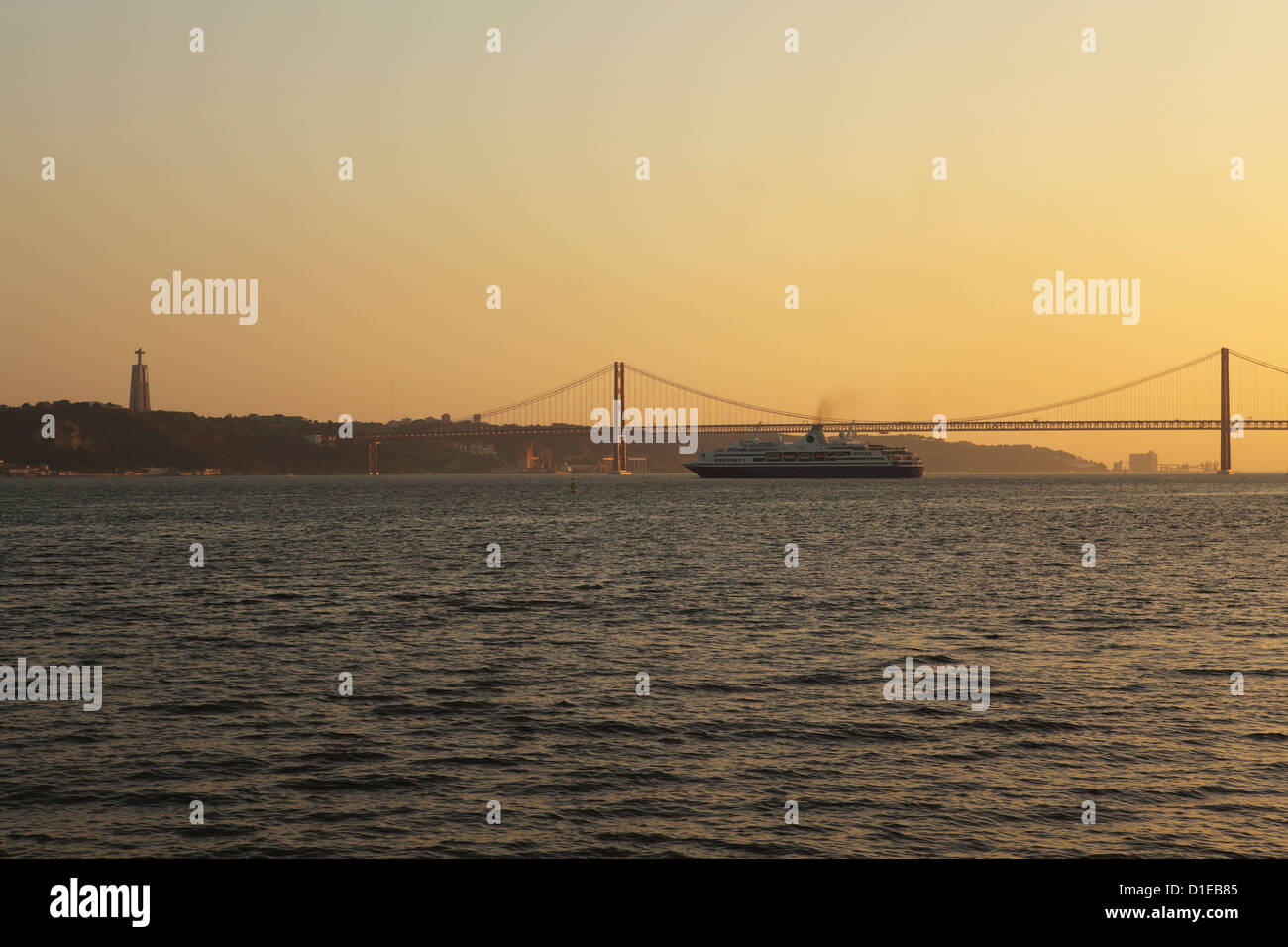 Un bateau de croisière se transforme en le coucher du soleil, sur le Tage, sous le pont du 25 avril et Christus Rei statue, Lisbonne, Portugal Banque D'Images