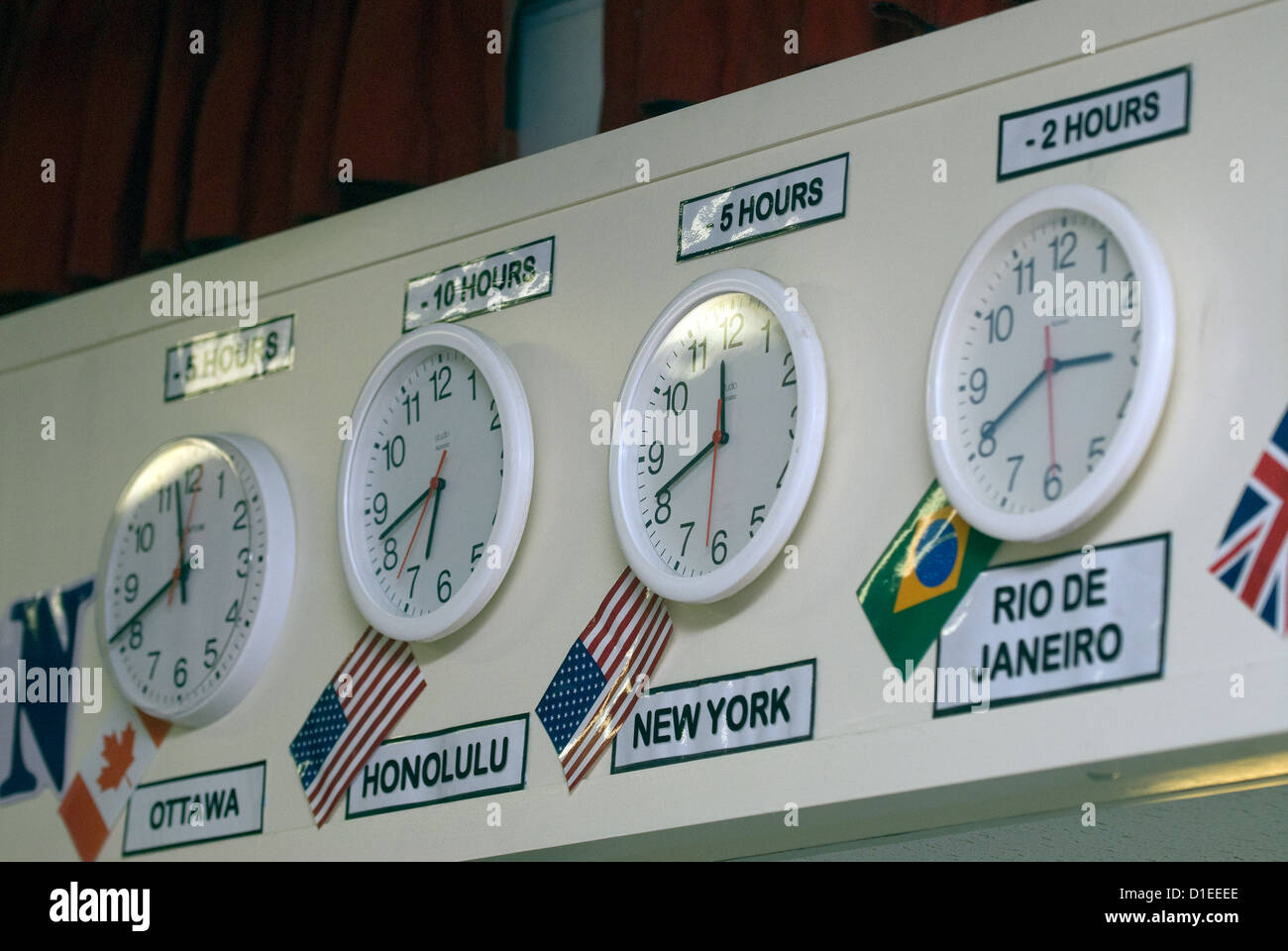 Dans une école d'horloges affichant des différences de fuseaux horaires, hindhead, Hampshire, Royaume-Uni. Banque D'Images