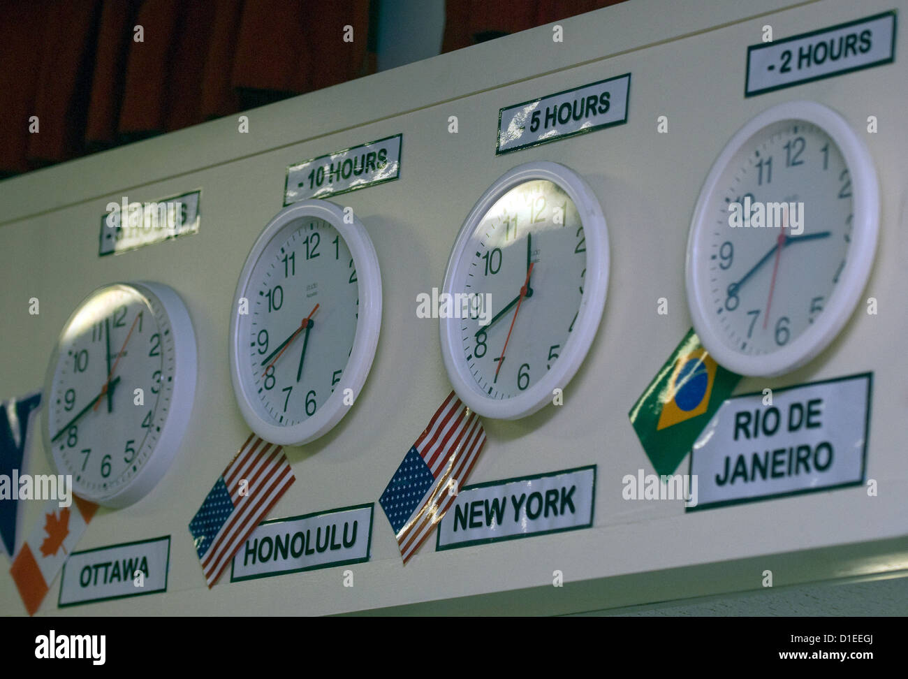 Dans une école d'horloges affichant des différences de fuseaux horaires, hindhead, Hampshire, Royaume-Uni. Banque D'Images