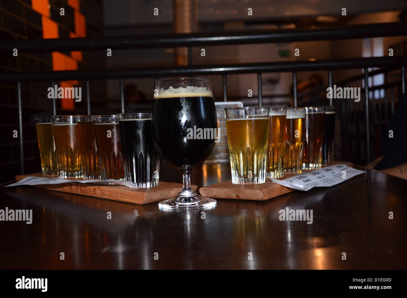 Verre de bière noire à l'avant et certaines bouteilles en verre avec de la bière en arrière-plan Banque D'Images