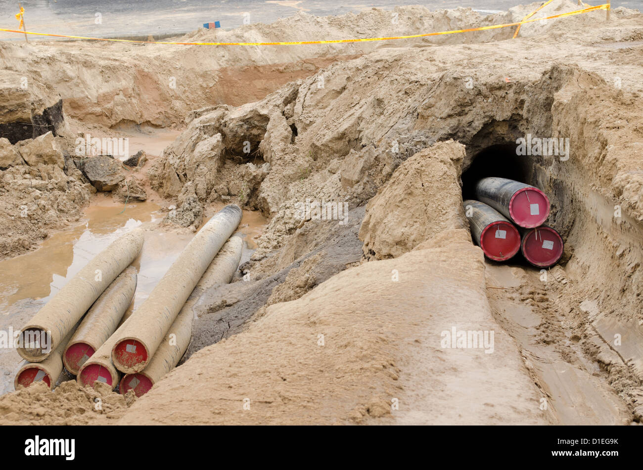 Les fils des câbles d'électricité avec tube de protection mises de l'industrie de la construction de la communication souterraine. Banque D'Images