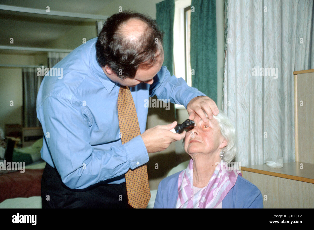 Un chirurgien consultant contrôle de l'œil d'un patient qui vient de subir une chirurgie de la cataracte. Banque D'Images
