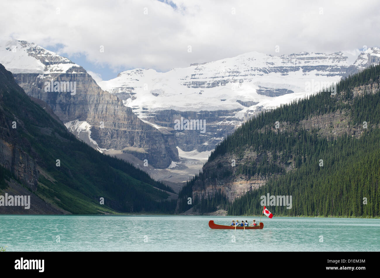 Red Canoe crossing Lake Louise avec drapeau canadien Banque D'Images