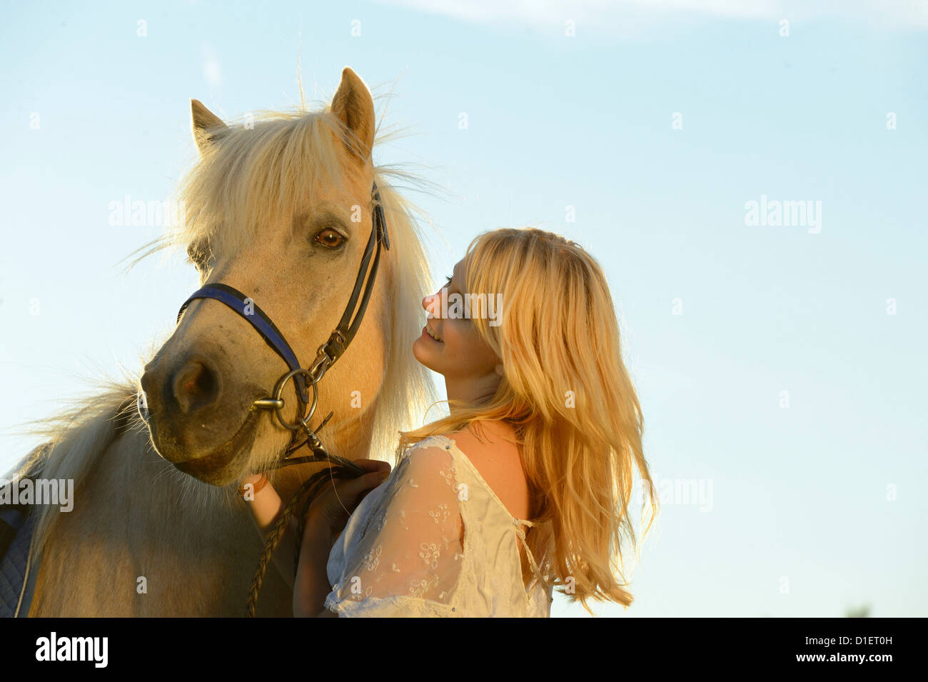 Smiling woman in white dress with horse Banque D'Images
